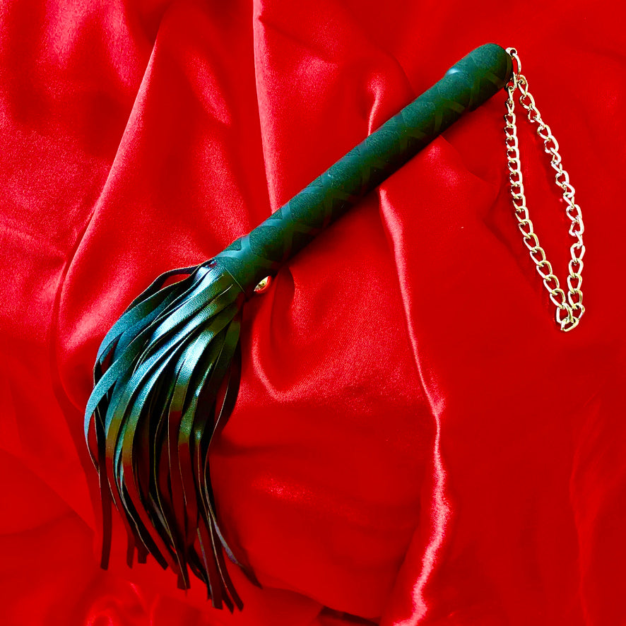 Experience the thrill of impact play with our Enter-tame Me Whip, made of 100% vegan leather and metal. Its 10-inch whip length and comfortable 6-inch handle make it perfect for exploring new sensations and pushing boundaries in your BDSM play. Shown in black.